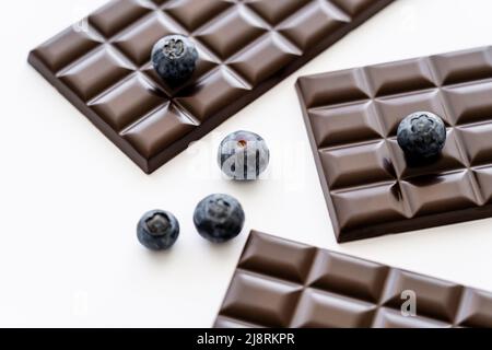 Vue rapprochée des bleuets et des barres de chocolat sur fond blanc Banque D'Images