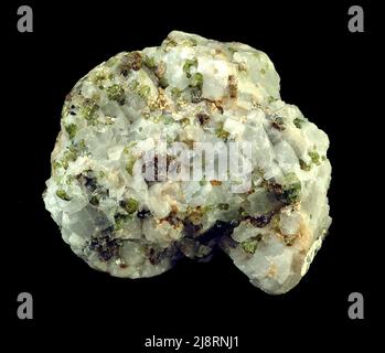 Diopside et calcite (marbre diopside). Cet échantillon est d'environ 5 cm. Le diopside, CaMgSi2O6 (silicate de calcium et de magnésium), est un minéral qui forme des roches dans plusieurs roches métamorphiques et ignées. Diopside appartient à la famille des pyroxènes. Le diopside vient du grec « dis- » signifiant « deux sortes » et « opsis- » signifiant « opinion ». Les meilleurs échantillons de diopside viennent d'Italie. Banque D'Images