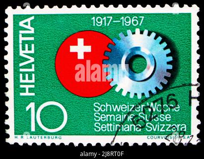 MOSCOU, RUSSIE - 14 MAI 2022 : timbre-poste imprimé en Suisse montre une roue dentée et un badge de la semaine suisse, série Publicité (1967), vers 1967 Banque D'Images