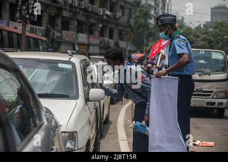 Un membre de Rover Scout remet un dépliant de sensibilisation au conducteur dans la rue pendant la campagne No Horn à Dhaka. La pollution sonore est devenue un problème important au Bangladesh. Le ministère de l'Environnement, sous la direction du ministère de l'Environnement, des forêts et des changements climatiques, a organisé une campagne « No Horn » et un tribunal mobile le 17th mai pour réduire la pollution sonore. La campagne se déroulera de 11 h à 4 h dans les intersections Gulshan-1. Cette campagne & Mobile court est destinée à développer la conscience des conducteurs et des propriétaires de véhicules. Pour qu'ils puissent réaliser les démerses de la pollution sonore et contrôler les honkin Banque D'Images