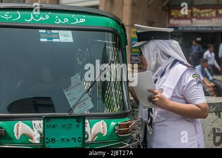 Un membre de Rover Scout remet un dépliant de sensibilisation au conducteur dans la rue pendant la campagne No Horn à Dhaka. La pollution sonore est devenue un problème important au Bangladesh. Le ministère de l'Environnement, sous la direction du ministère de l'Environnement, des forêts et des changements climatiques, a organisé une campagne « No Horn » et un tribunal mobile le 17th mai pour réduire la pollution sonore. La campagne se déroulera de 11 h à 4 h dans les intersections Gulshan-1. Cette campagne & Mobile court est destinée à développer la conscience des conducteurs et des propriétaires de véhicules. Pour qu'ils puissent réaliser les démerses de la pollution sonore et contrôler les honkin Banque D'Images