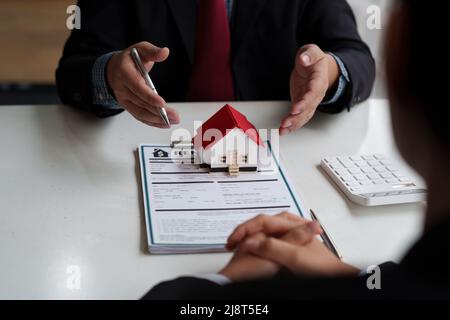 Agent immobilier et client signature contrat pour acheter maison, assurance ou prêt immobilier.louer une maison, obtenir assurance ou prêt immobilier ou bien immobilier Banque D'Images