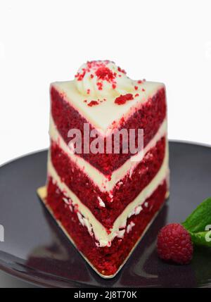 Une tranche de gâteau à la framboise sur une assiette blanche sur fond blanc Banque D'Images