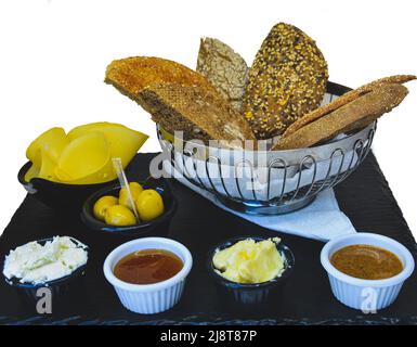 Petit-déjeuner marocain en marbre noir avec pain blanc mélangé à la confiture, au beurre, aux olives et à la salade de fruits Banque D'Images