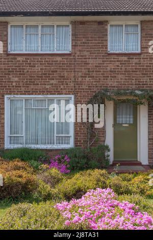 Maison, style 1940s, avec fenêtres de style critall, jardin avant avec pelouse et bruyère. Banque D'Images
