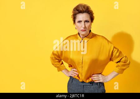 Femme en colère en chemise jaune sur fond jaune Banque D'Images