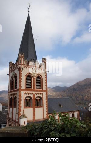 Saint-Pierre Kirche, église, avec des oiseaux volant autour de la tour de l'horloge lors d'un ciel nuageux journée d'automne à Bacharach, Allemagne. Banque D'Images