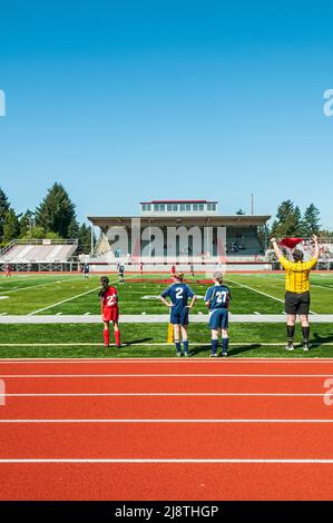 Joueurs de football pour filles sur le terrain de football/football et sur les lignes latérales du circuit et du terrain de football de l'école secondaire David Douglas à Portland, Oregon. Banque D'Images