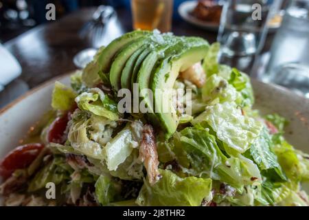 Vue sur une salade décadente de crabe et d'avocat, sur une assiette blanche et dorée, dans un restaurant haut de gamme Banque D'Images