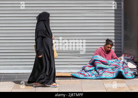 Femme asiatique sans abri dormant sur le trottoir avec un sac de couchage bleu. Homelesss femmes asiatiques dormant dans les rues du centre-ville de Preston, Royaume-Uni Banque D'Images