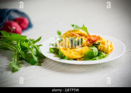 Omelette aux œufs farcie à la tomate et aux légumes verts frits sous forme de gaufres, sur une table en bois. Banque D'Images