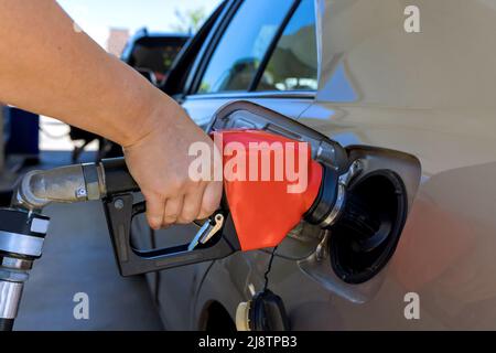 Femme pompant de l'essence dans la voiture à la station-service Banque D'Images