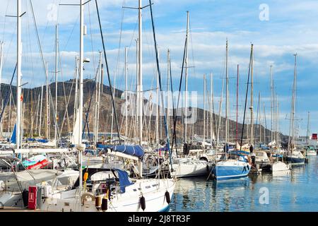 Marina avec yachts blancs sous ciel orageux, montagnes en arrière-plan, Italie Banque D'Images