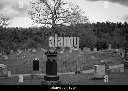 Un vieux cimetière a l'air étrange même à la lumière du jour, avec sa collection de pierres de tête abîmés Banque D'Images