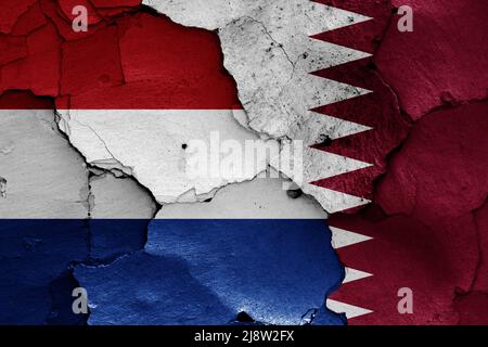 Drapeaux des pays-Bas et du Qatar peints sur un mur fissuré Banque D'Images