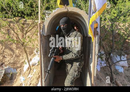 Beit Hanoun, Territoires palestiniens. 18th mai 2022. Un membre de Saraya al-Quds, l'aile militaire du mouvement du Jihad islamique en Palestine, prend place devant un tunnel militaire près du festival « Sword of Jerusalem » à Beit Hanoun, dans le nord de la bande de Gaza, qui célèbre le premier anniversaire de la guerre à Gaza. Credit: Mohammed Talatene/dpa/Alay Live News Banque D'Images