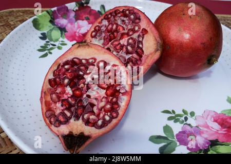 Fruits de couleur rouge à la grenade fraîchement coupés, avec graines à l'intérieur Banque D'Images