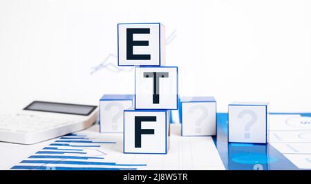 Investir dans des fonds négociés en bourse. Cubes avec abréviation ETF, calculatrice et graphiques. Concept financier. Faire des investissements dans les actions, les obligations et les matières premières. Photo de haute qualité Banque D'Images