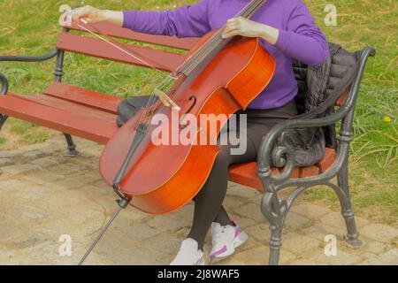 La violoncelliste tient le violoncelle, la contrebasse dans ses mains. La fillette joue le violoncelle. Musiciens de rue . . Banque D'Images