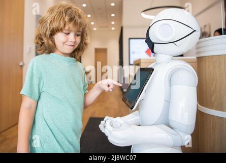 le garçon interagit avec l'intelligence artificielle de robot, la communication Banque D'Images