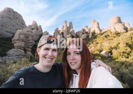 deux jeunes hommes et randonneurs, prenant un selfie du sommet de la montagne avec leur smartphone. Monserrat Espagne Banque D'Images