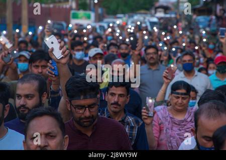 Srinagar, Inde. 17th mai 2022. Les Hindous de Kashmiri, connus localement sous le nom de « pandus », tiennent des lampes de poche mobiles pendant la manifestation à Budgam contre le meurtre de Rahul Bhat, un employé du gouvernement qui a été tué par balle par des rebelles présumés dans son bureau de Chadoora Budgam. Alors que les autorités indiennes ont assuré à la communauté de Kashmiri Pandit que tous les problèmes liés à l'emploi et à la sécurité seront résolus dans une semaine, la communauté exige un transfert de la région du Cachemire le plus tôt possible, en disant qu'ils ne peuvent pas risquer leur vie pour un emploi. Crédit : SOPA Images Limited/Alamy Live News Banque D'Images