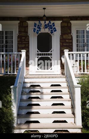 Escaliers menant à la véranda sur l'ancienne maison en pierre de style cottage Canadiana 1831. Banque D'Images