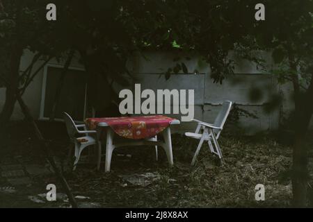 Tables et chaises dans le jardin créepy Banque D'Images