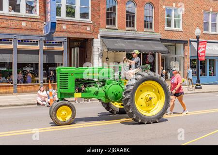 Le jeune fils de Travis et Gina Vaughn conduit un vieux tracteur John Deere Banque D'Images