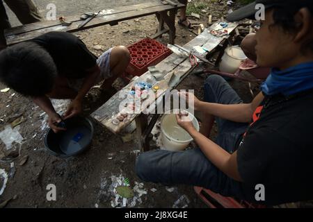 Les ouvriers qui polissaient des souvenirs d'ornement de type ambre dans une boutique située en bordure de route à Lembah Harau, Harau, Lima Puluh Kota, Sumatra Ouest, Indonésie. Banque D'Images