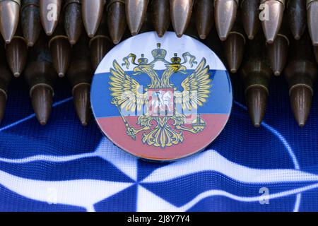 Drapeau russe sur un drapeau de l'OTAN avec une ceinture de munitions Banque D'Images