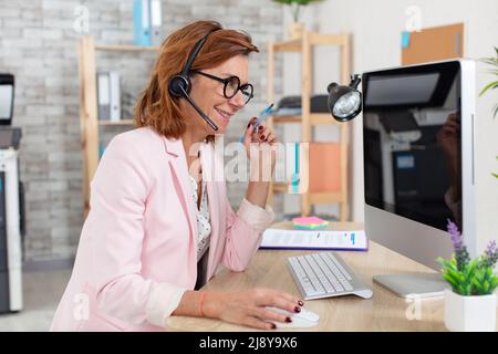 femme d'affaires souriante et âgée en lunettes Banque D'Images