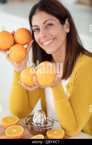 jolie femme aux cheveux sombres tenant un orange délicieux juteux Banque D'Images