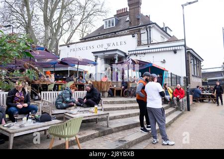 Les gens assis se relaxant en buvant debout devant le jardin de pub Princess of Wales au printemps sur la rivière Lea Clapton Londres E5 Angleterre KATHY DEWITT Banque D'Images