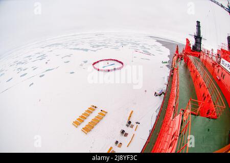 Les touristes forment un cercle au pôle Nord géographique pour célébrer leur arrivée à côté des 50 ans de victoire (50 Laissez Pobedy) brise-glace nucléaire Banque D'Images