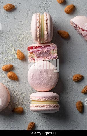 Macarons roses avec farine d'amande sur fond gris Banque D'Images