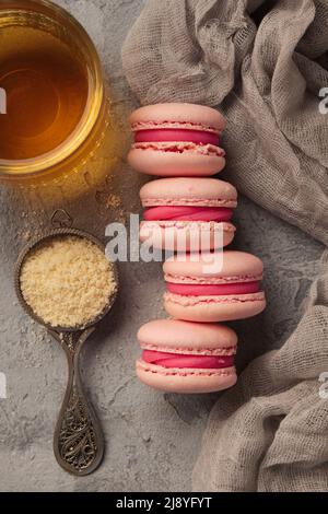 Macarons roses colorés sur une table grise Banque D'Images