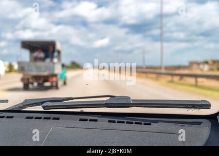 Point de vue passager d'une vieille voiture d'époque. Un ancien chariot est en mouvement et transporte des passagers dans la partie arrière. Le véhicule obsolète conduit dans le Banque D'Images