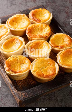 Queijadas portugais Cheesecake Tarts gros plan sur un plateau en bois sur la table. Verticale Banque D'Images