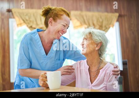 L'infirmière soignante ou l'infirmière gériatrique prend soin d'une femme âgée à la maison de soins infirmiers ou à la maison Banque D'Images