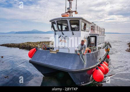 Le bateau touristique arrive à l'étape de l'atterrissage sur l'île de Staffa, Inner Hebrides, Écosse, Royaume-Uni Banque D'Images