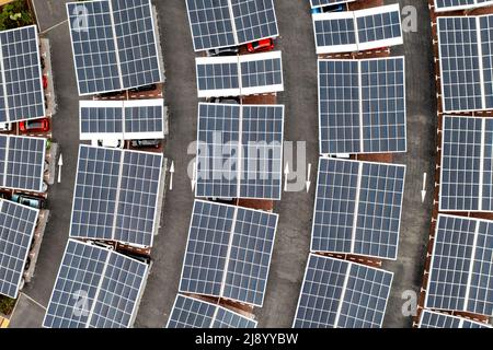 Vue aérienne au-dessus de panneaux solaires innovants situés sur les toits d'un parking de voiture faisant bon usage de petits espaces dans une ville Banque D'Images