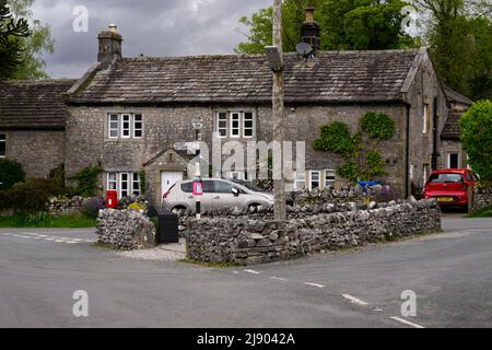 Calme Conistone village centre (belles propriétés en pierre de C18, jonction de route murée, signalisation) - Wharfedale, Yorkshire Dales, Angleterre, Royaume-Uni. Banque D'Images