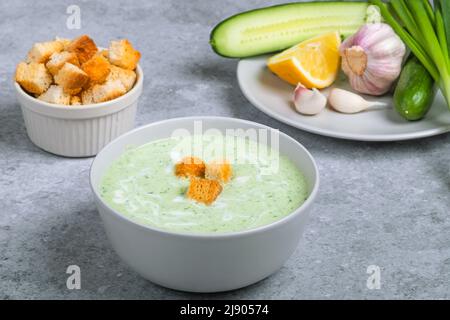 Soupe froide à la crème végétalienne avec concombre, yaourt, ail, herbes, citron et croûtons. Concept alimentaire. Plats végétariens et végétaliens Banque D'Images
