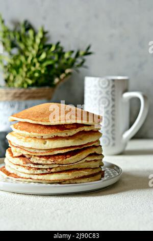 Pile de crêpes maison avec miel pour le petit déjeuner sur fond gris. Brunch. Banque D'Images