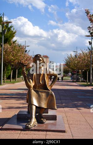 Statue de bronze de jeune femme vendant des fleurs avec bouqet en main au parc Banque D'Images