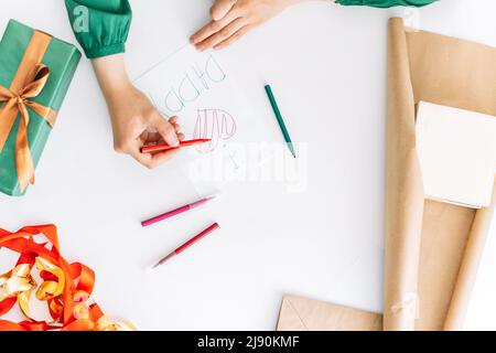 La fille est en train de faire une carte de vœux pour son père avec des stylos-feutres Banque D'Images