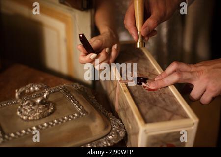 La mariée et le marié mettent un sceau de cire sur le cadeau Banque D'Images