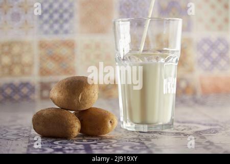 Lait de pomme de terre et pomme de terre sans lactose et respectueux de l'environnement sur l'assiette de la table. Lait de remplacement, non laitier. Mosaïque d'arrière-plan classique. Copier l'espace. Photo de haute qualité Banque D'Images