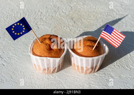 Muffins faits maison avec drapeaux américains et européens sur fond blanc, espace de copie. Le concept de coopération entre pays. Le concept des relations commerciales b Banque D'Images